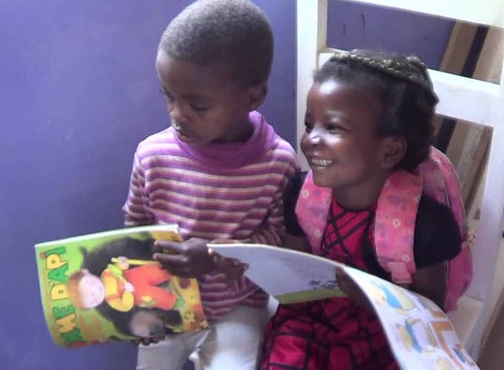Children reading donated books.